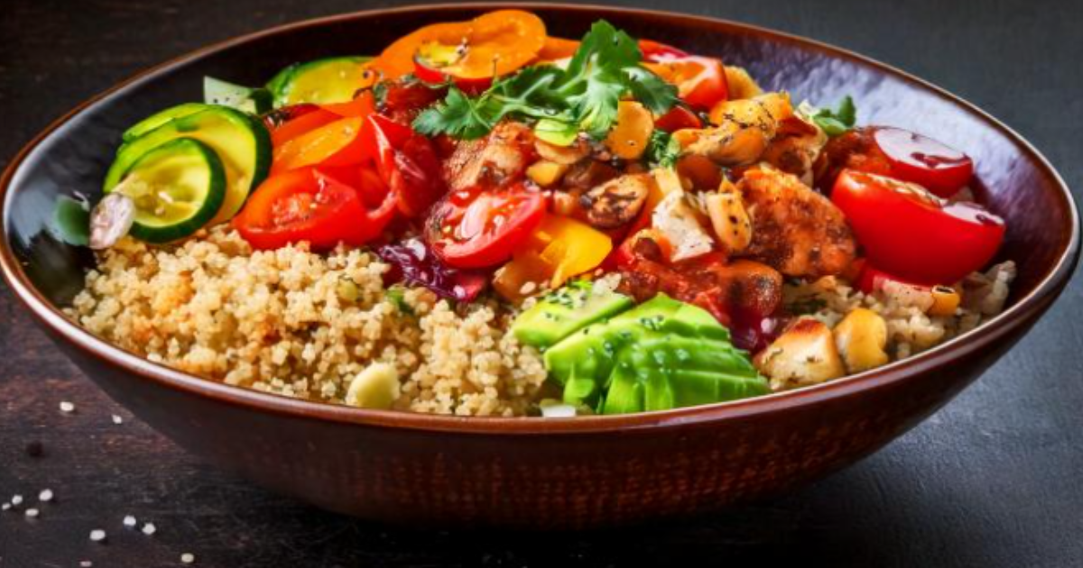 A vibrant quinoa bowl with grilled chicken, fresh vegetables like cherry tomatoes, cucumber, avocado, and topped with herbs, nuts, and a tangy sauce.